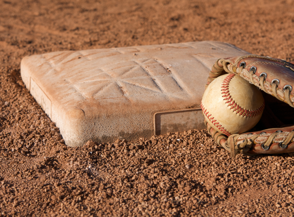 A catcher's mit with a ball inside of it next to home plate.