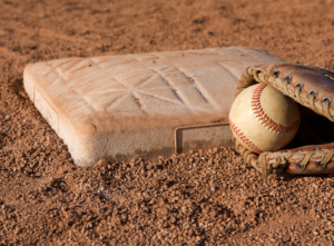 A catcher's mit with a ball inside of it next to home plate.