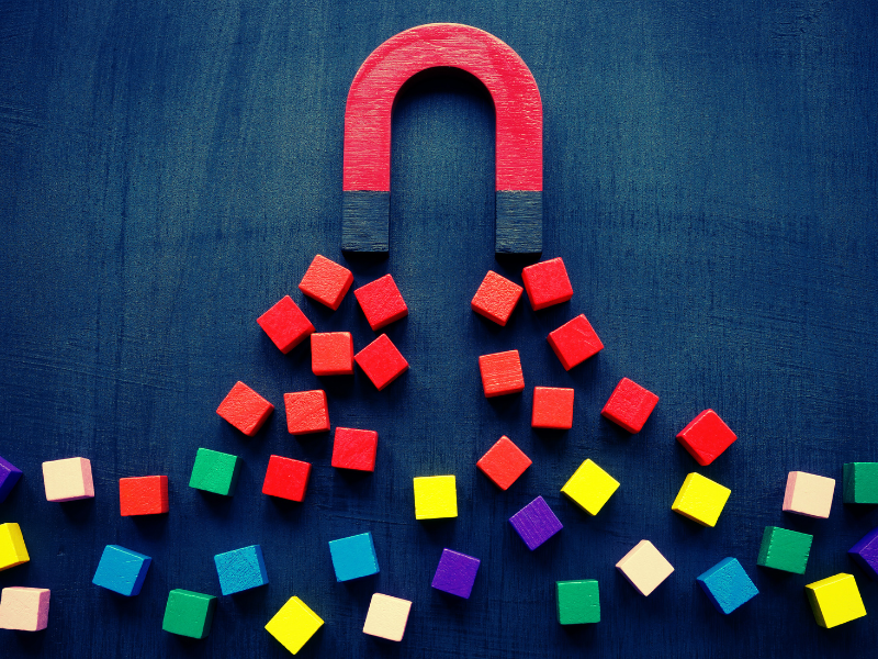 A big magnet attracting square blocks.